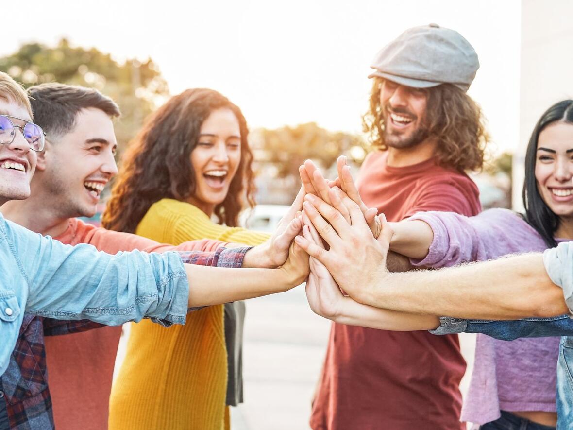 Eine Gruppe von jungen Menschen die alle gemeinsam einschlagen